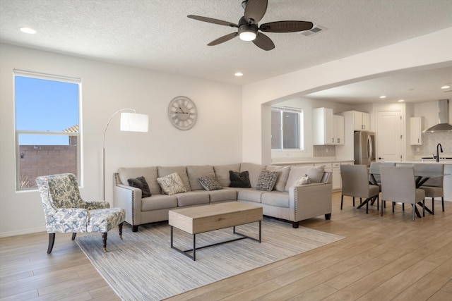 3003 Turquesa SE, Rio Rancho, NM 87124 - living area featuring light wood finished floors, ceiling fan, a textured ceiling, recessed lighting, and baseboards