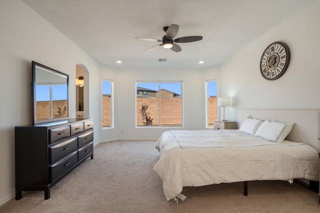 3003 Turquesa SE, Rio Rancho, NM 87124 - bedroom featuring light carpet, multiple windows, arched walkways, recessed lighting, and a textured ceiling