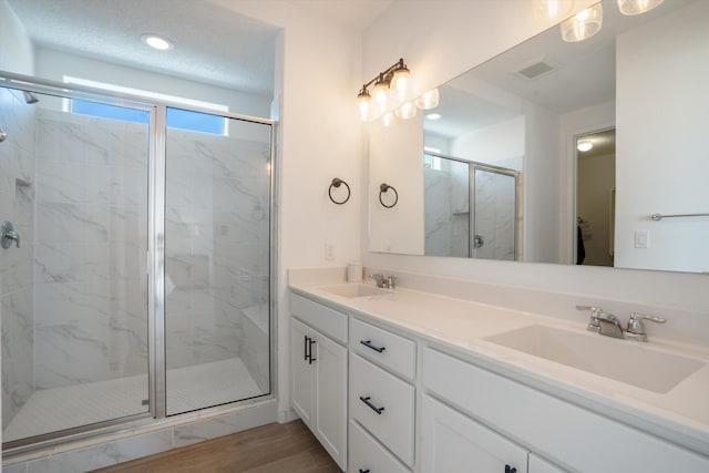 3003 Turquesa SE, Rio Rancho, NM 87124 - bathroom with a stall shower, wood finished floors, double vanity, and recessed lighting
