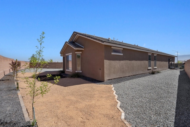 3003 Turquesa SE, Rio Rancho, NM 87124 - view of side of home with a fenced backyard, stucco siding, and a patio