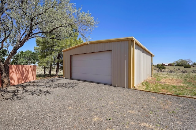 detached garage with gravel driveway
