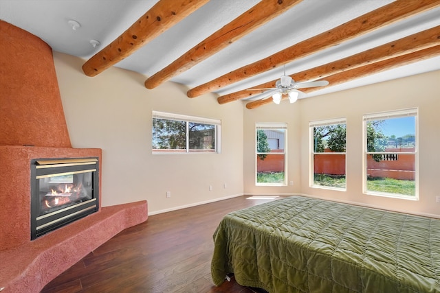 bedroom with baseboards, multiple windows, dark wood finished floors, and beam ceiling
