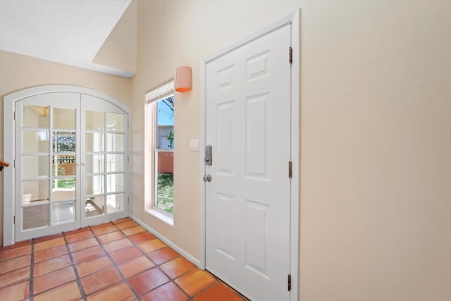 doorway to outside with baseboards and light tile patterned flooring