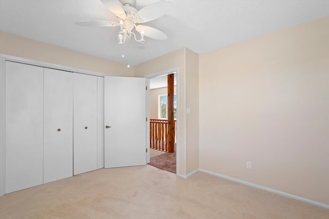 unfurnished bedroom with a ceiling fan, light carpet, and a closet