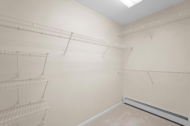 spacious closet featuring carpet floors and a baseboard radiator