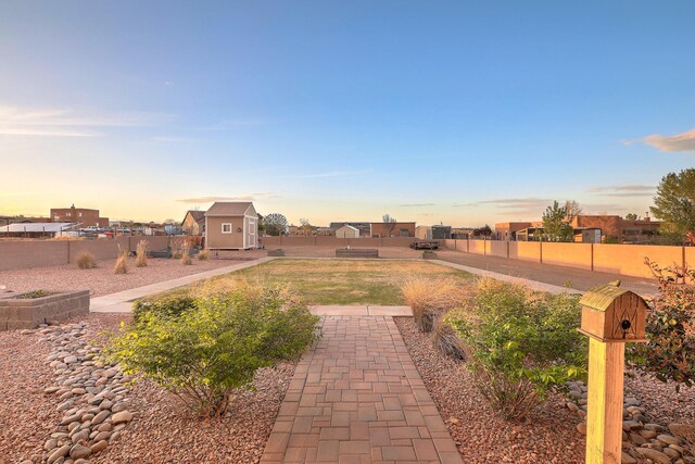 1797 Vargas Rd SE, Rio Rancho, NM 87124 - yard at dusk featuring a storage shed and a fenced backyard