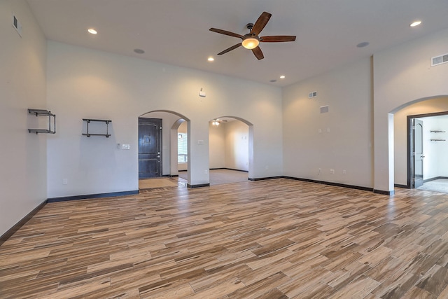 1797 Vargas Rd SE, Rio Rancho, NM 87124 - unfurnished living room featuring a ceiling fan, arched walkways, wood finished floors, and recessed lighting