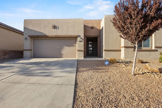 9109 Retablo Rd NW, Albuquerque, NM 87120 - pueblo-style house with stucco siding, an attached garage, and driveway