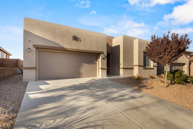 9109 Retablo Rd NW, Albuquerque, NM 87120 - pueblo revival-style home with an attached garage, driveway, and stucco siding