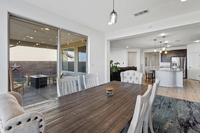 9109 Retablo Rd NW, Albuquerque, NM 87120 - dining area featuring light wood-type flooring and visible vents