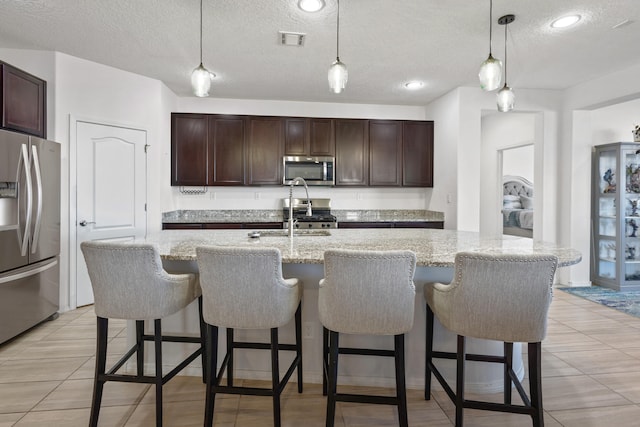 9109 Retablo Rd NW, Albuquerque, NM 87120 - kitchen with dark brown cabinetry, appliances with stainless steel finishes, a sink, and visible vents