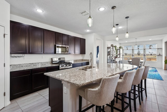 9109 Retablo Rd NW, Albuquerque, NM 87120 - kitchen featuring visible vents, a breakfast bar area, stainless steel appliances, and a sink
