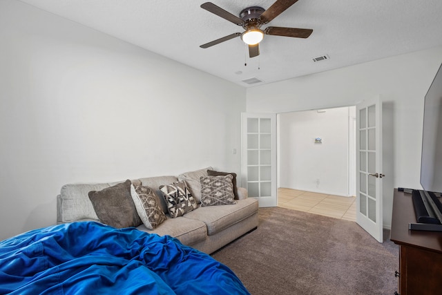 9109 Retablo Rd NW, Albuquerque, NM 87120 - carpeted living room with visible vents, a ceiling fan, tile patterned floors, and french doors