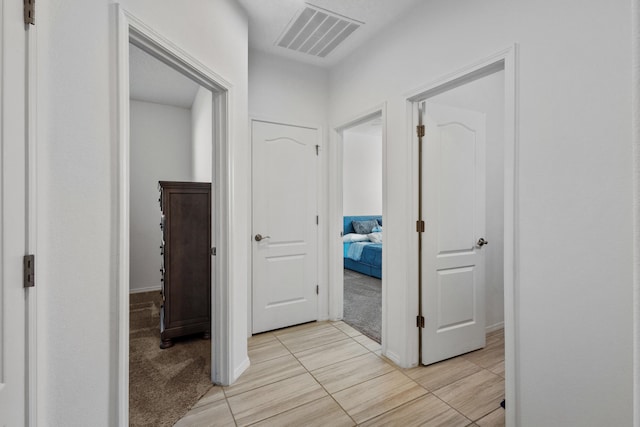 9109 Retablo Rd NW, Albuquerque, NM 87120 - corridor with visible vents, baseboards, and light carpet