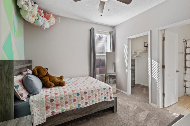 9109 Retablo Rd NW, Albuquerque, NM 87120 - bedroom featuring a textured ceiling, baseboards, carpet, a spacious closet, and a ceiling fan