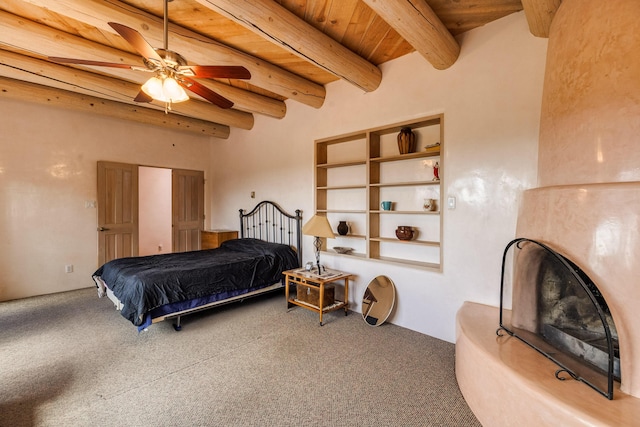 carpeted bedroom featuring wood ceiling, a high end fireplace, a ceiling fan, and beam ceiling