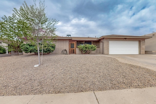 ranch-style house featuring brick siding, an attached garage, and concrete driveway
