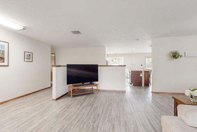living room featuring light wood-type flooring, baseboards, visible vents, and recessed lighting