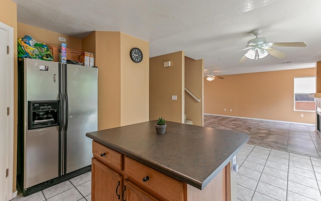 7419 Tolleson Ave NW, Albuquerque, NM 87114 - kitchen featuring a ceiling fan, dark countertops, open floor plan, light tile patterned floors, and stainless steel fridge