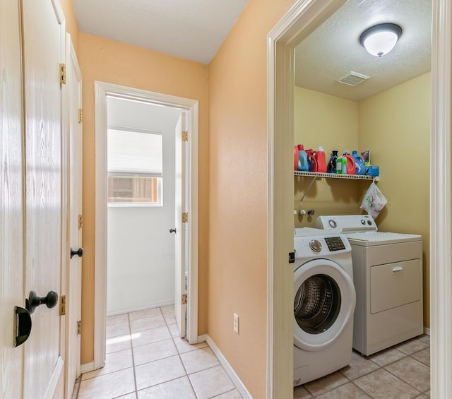 7419 Tolleson Ave NW, Albuquerque, NM 87114 - washroom featuring washing machine and clothes dryer, visible vents, laundry area, and light tile patterned floors
