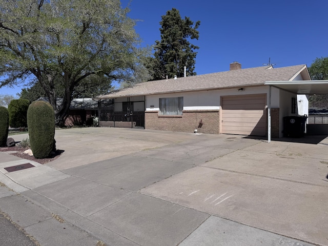 6329 Prairie Rd NE, Albuquerque, NM 87109 - ranch-style house with fence, a chimney, brick siding, an attached garage, and driveway
