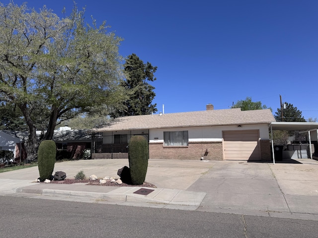 6329 Prairie Rd NE, Albuquerque, NM 87109 - ranch-style home with an attached garage, brick siding, a chimney, concrete driveway, and a carport