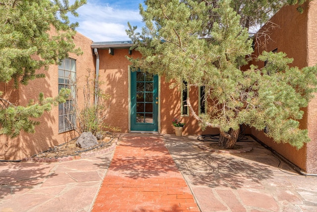 view of exterior entry featuring stucco siding