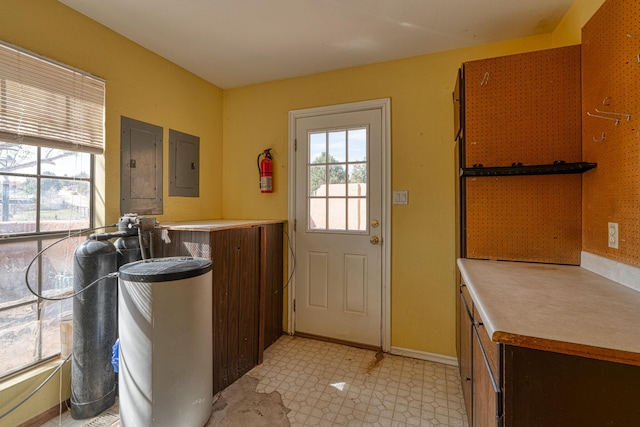 entryway featuring electric panel, light flooring, and baseboards