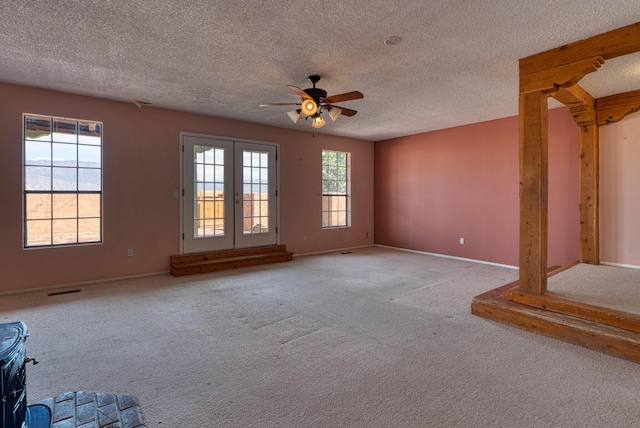 unfurnished living room featuring carpet, a ceiling fan, baseboards, and a textured ceiling