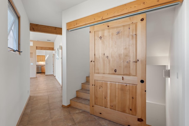 hall featuring stairway, tile patterned flooring, and baseboards