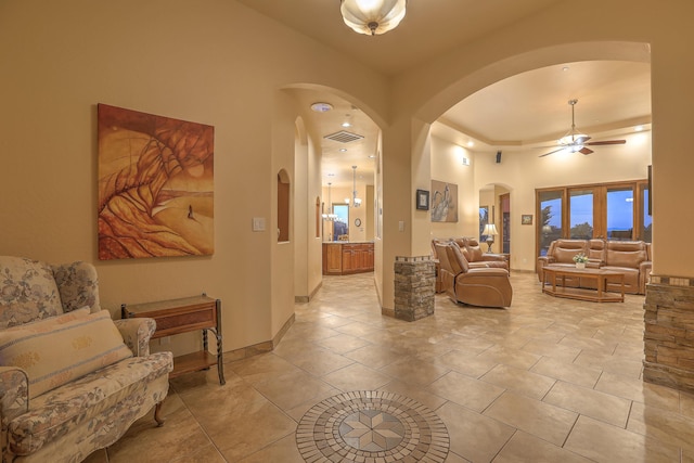 255 Diamond Tail Rd, Placitas, NM 87043 - living area with arched walkways, a ceiling fan, light tile patterned flooring, and a towering ceiling