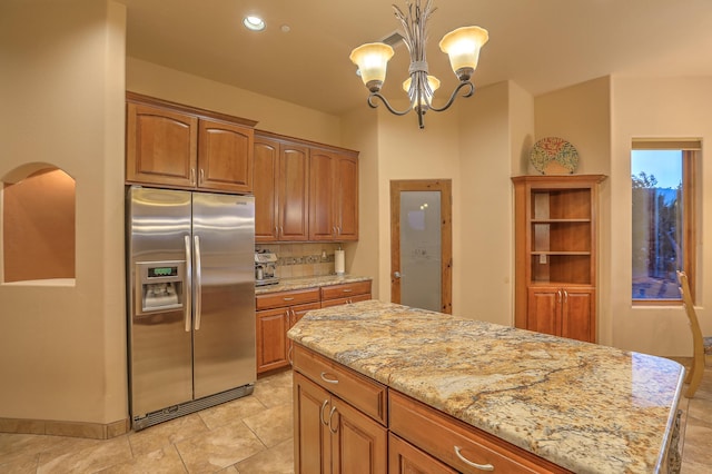 255 Diamond Tail Rd, Placitas, NM 87043 - kitchen with stainless steel fridge with ice dispenser, a chandelier, light stone countertops, tasteful backsplash, and hanging light fixtures
