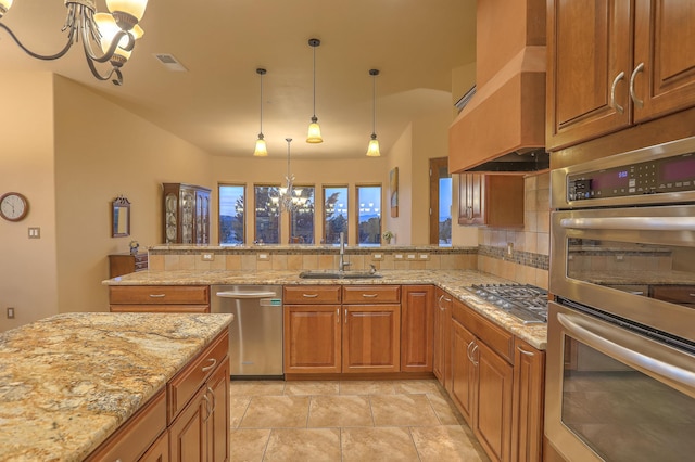 255 Diamond Tail Rd, Placitas, NM 87043 - kitchen with appliances with stainless steel finishes, a chandelier, custom exhaust hood, brown cabinets, and decorative backsplash