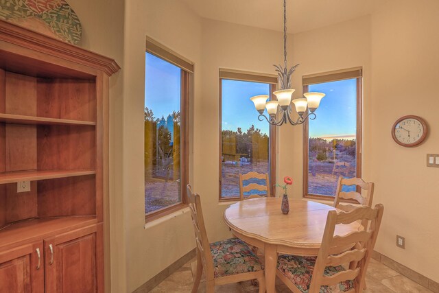 dining area with light tile patterned flooring, a chandelier, and baseboards