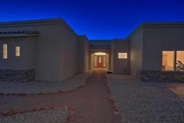 255 Diamond Tail Rd, Placitas, NM 87043 - view of exterior entry featuring stucco siding, a tile roof, and stone siding