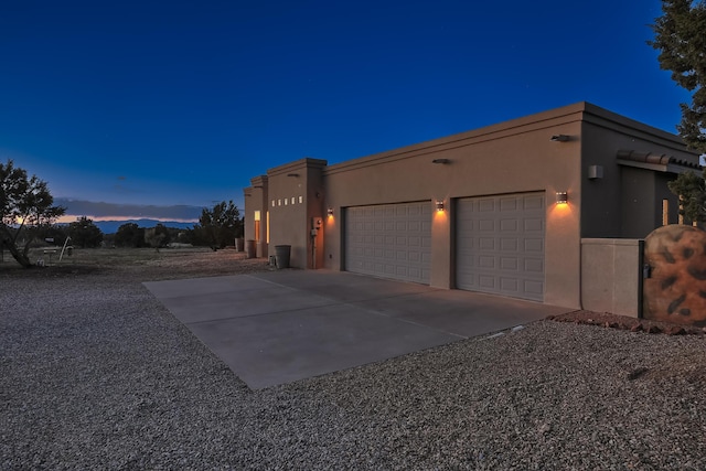 view of front of home featuring stucco siding, concrete driveway, and an attached garage