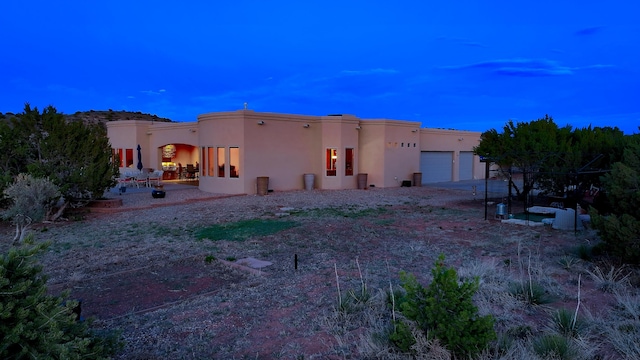 255 Diamond Tail Rd, Placitas, NM 87043 - rear view of property with stucco siding, a garage, driveway, and a patio