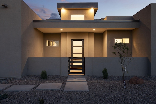 262 Diamond Tail Rd, Placitas, NM 87043 - exterior entry at dusk with stucco siding