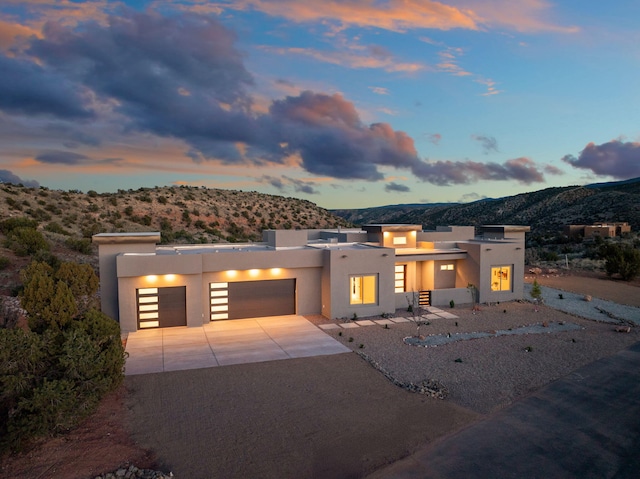 262 Diamond Tail Rd, Placitas, NM 87043 - view of front of house with an attached garage, a mountain view, stucco siding, and concrete driveway