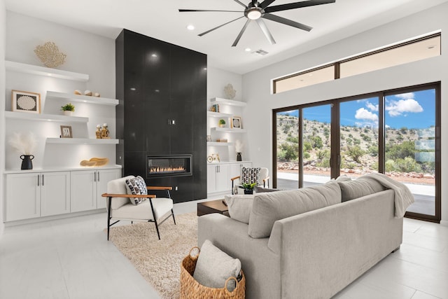 262 Diamond Tail Rd, Placitas, NM 87043 - living room with a high ceiling, ceiling fan, a fireplace, built in shelves, and visible vents