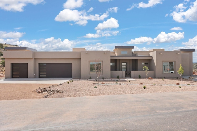 262 Diamond Tail Rd, Placitas, NM 87043 - pueblo-style house featuring an attached garage, driveway, and stucco siding