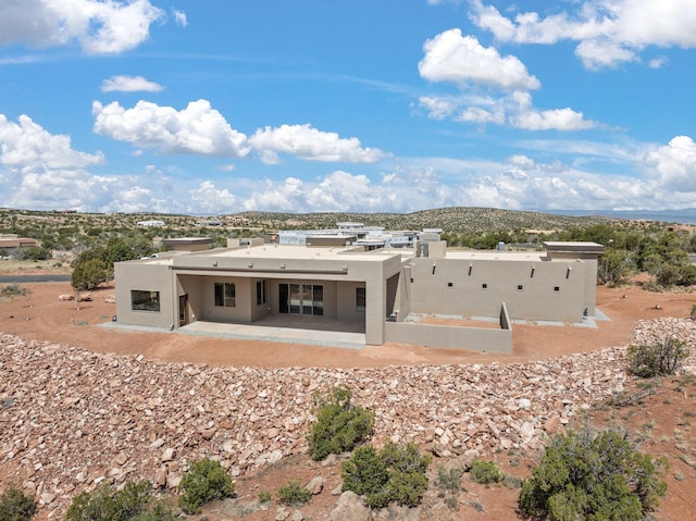 262 Diamond Tail Rd, Placitas, NM 87043 - rear view of house featuring stucco siding and a patio area