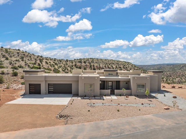 262 Diamond Tail Rd, Placitas, NM 87043 - view of front of house with a mountain view, stucco siding, an attached garage, and driveway