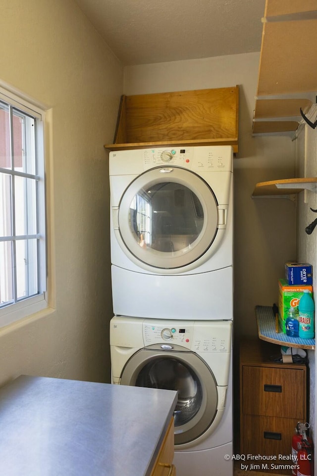 laundry area featuring stacked washing maching and dryer and laundry area