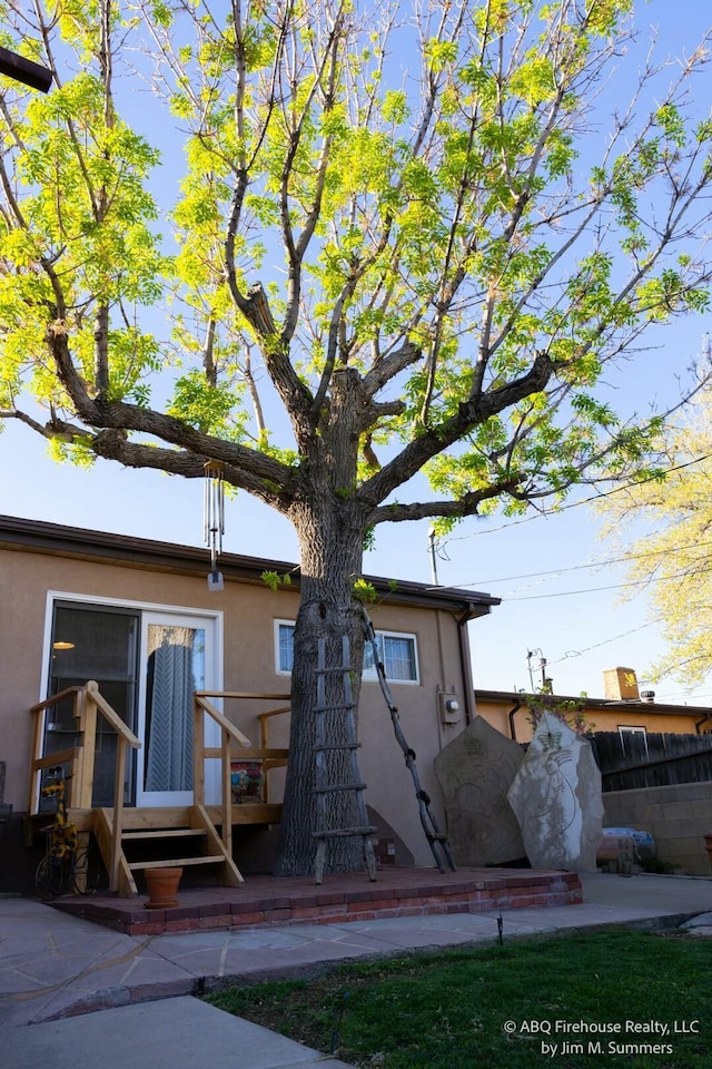 rear view of house featuring stucco siding