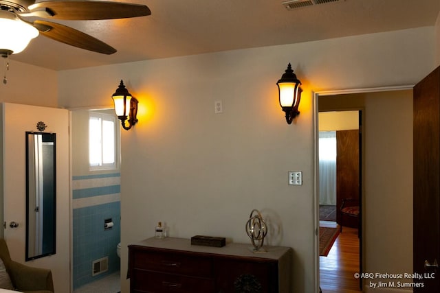 hallway with visible vents and wood finished floors