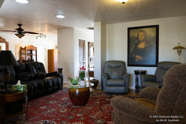 living area featuring recessed lighting, a textured ceiling, ceiling fan, and baseboards