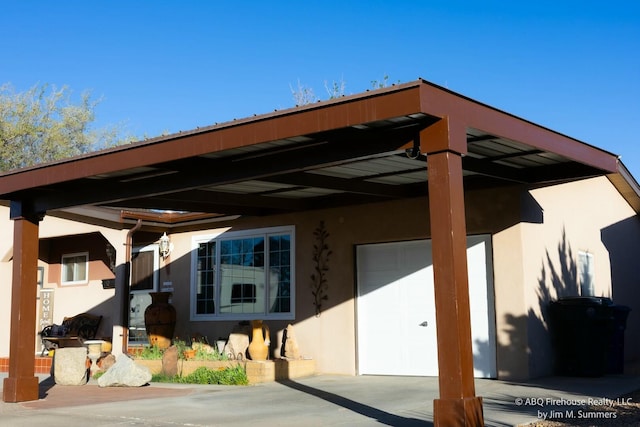 entrance to property featuring an attached garage, a carport, and stucco siding
