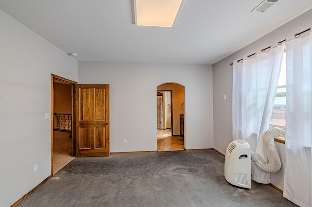 5016 Frontier Rd NE, Rio Rancho, NM 87144 - spare room featuring arched walkways, visible vents, and baseboards