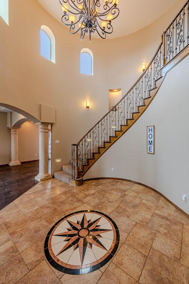 5016 Frontier Rd NE, Rio Rancho, NM 87144 - entryway featuring stairway, a towering ceiling, ornate columns, baseboards, and a notable chandelier